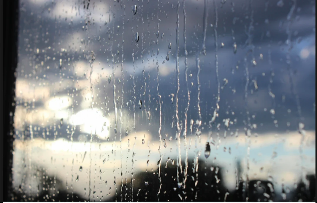 Pluie et ciel orageux en Algérie Fenêtre avec gouttes de pluie et ciel orageux en arrière-plan.