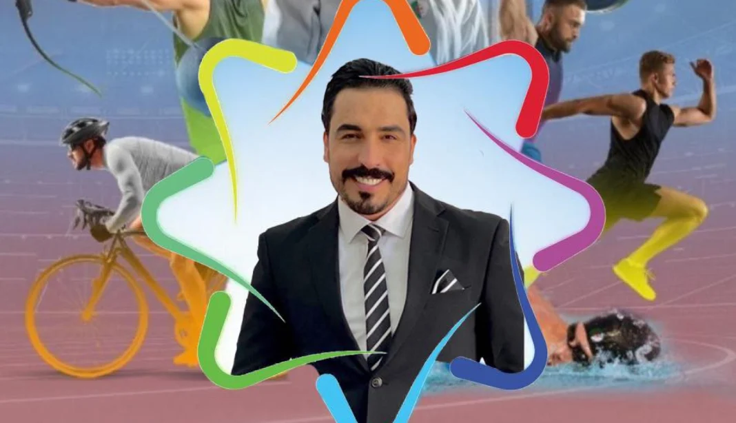 Yahya Tabish : j’ai menti sur une actualité aux Jeux Méditerranéens Yahya Tabish en costume lors des Jeux Méditerranéens avec des athlètes en arrière-plan.