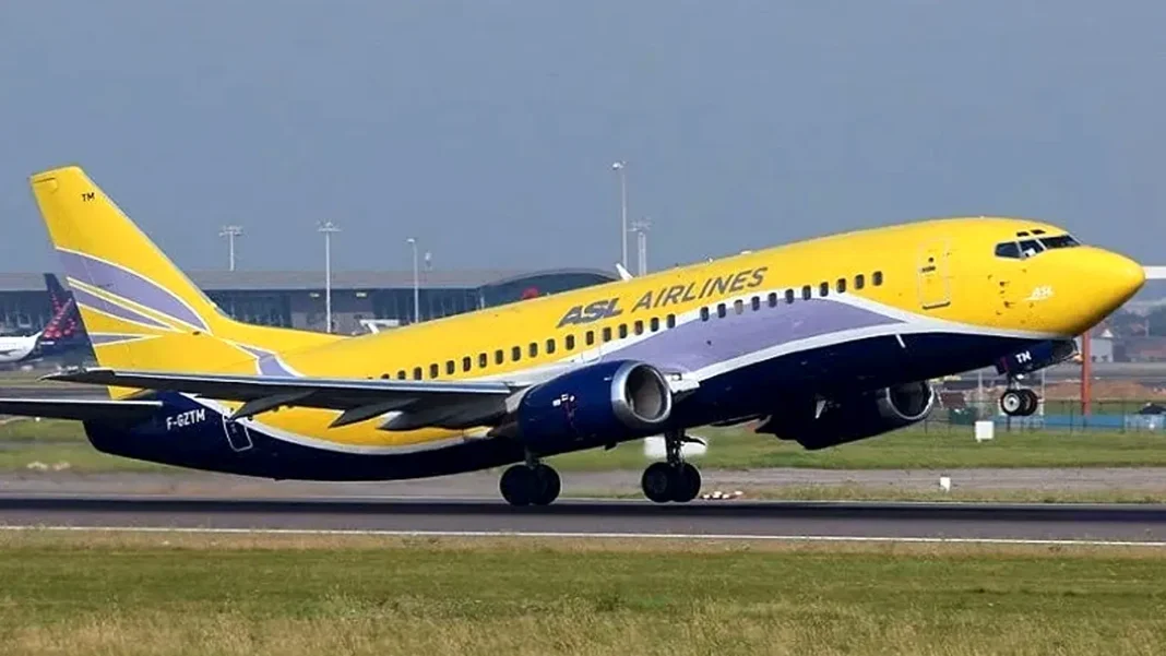 Avion jaune d'ASL Airlines en atterrissage sur piste d'aéroport.