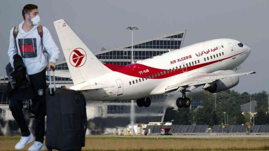 Vols d’été 2022: Air Algérie annonce un nouveau programme avec la vente des billets vers la France Passager avec masque et bagages près d’un avion Air Algérie.