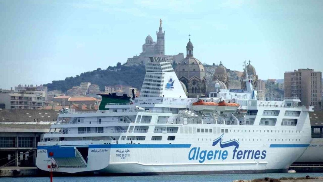 Ferry Algérie-Tunisie en Méditerranée Ferry Algérie-Tunisie naviguant en Méditerranée avec ville en arrière-plan.