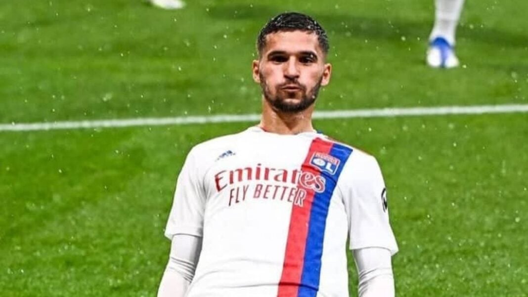 Aouar lors d'un match de football Aouar en tenue de football sur le terrain sous la pluie.