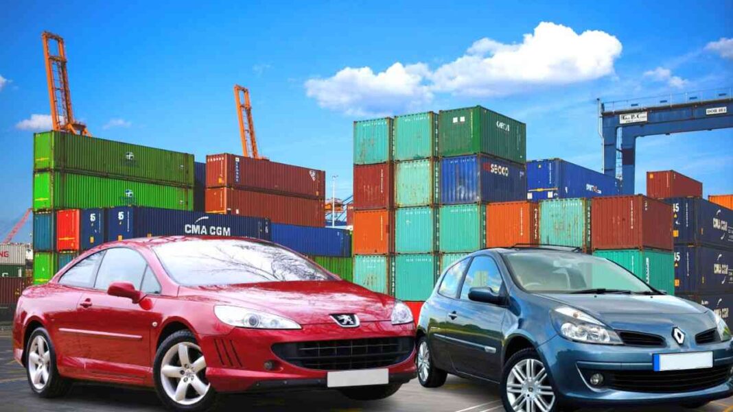 Algérie/Importation voitures en 2023 : point sur le dossier des demandes d’autorisations Voitures neuves et conteneurs dans un port maritime en plein jour.