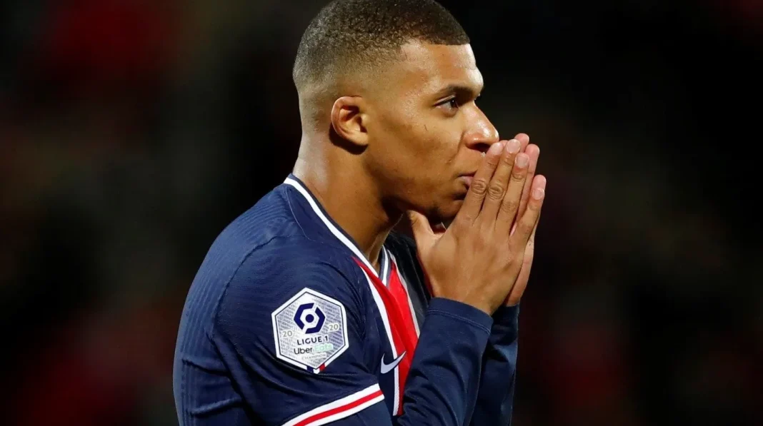 Kylian Mbappé en pleine réflexion lors d'un match de football.