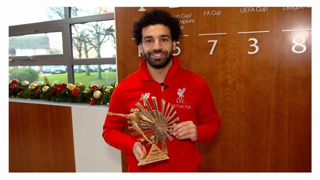 Mohamed Salah élu meilleur joueur de la Premier League Mohamed Salah tenant un trophée, souriant, en tenue de Liverpool.