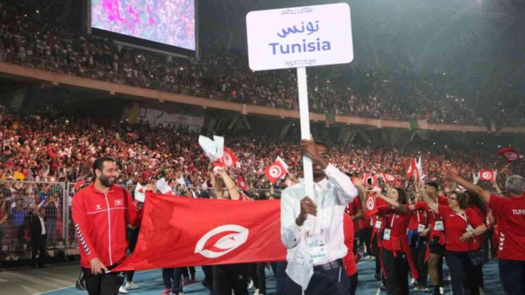 JM Oran 2022 : les supporters algériens accusés de sifflement lors du passage de l’hymne national tunisien Supporters tunisiens avec drapeau et panneau Tunisie au stade.