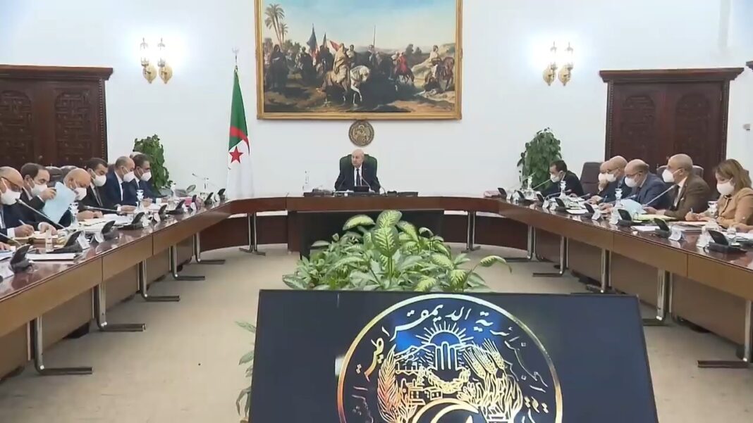 Voici le texte intégral du communiqué du conseil des ministres Réunion du conseil des ministres en Algérie avec drapeau national et décor traditionnel.