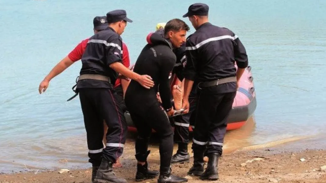 Équipe de sauveteurs aidant un nageur en détresse sur la plage.