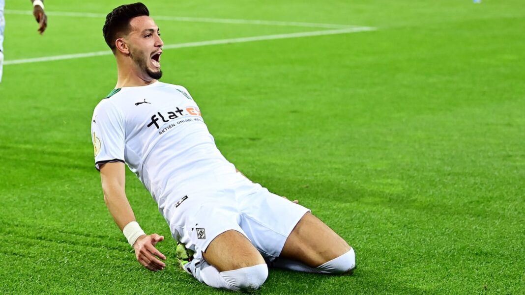 Ramy Bensebaïni célèbre un but sur le terrain de football.