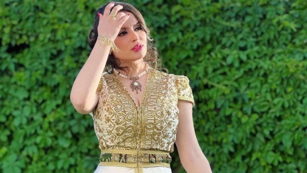 Halyma Alma et son budget fou pour le shopping Halyma Alma en tenue chic avec un fond de verdure luxuriante.