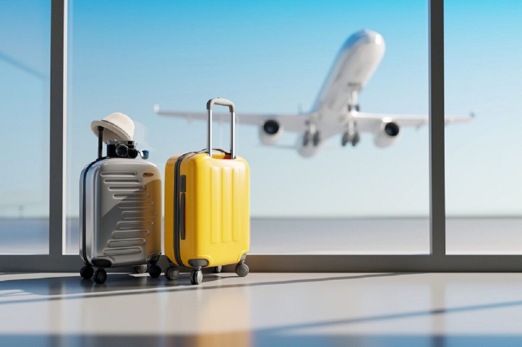 Une agence de voyage ferme ses portes et bloque les voyageurs algériens à cause de … Valises de voyage près de la fenêtre avec avion en vol en arrière-plan.