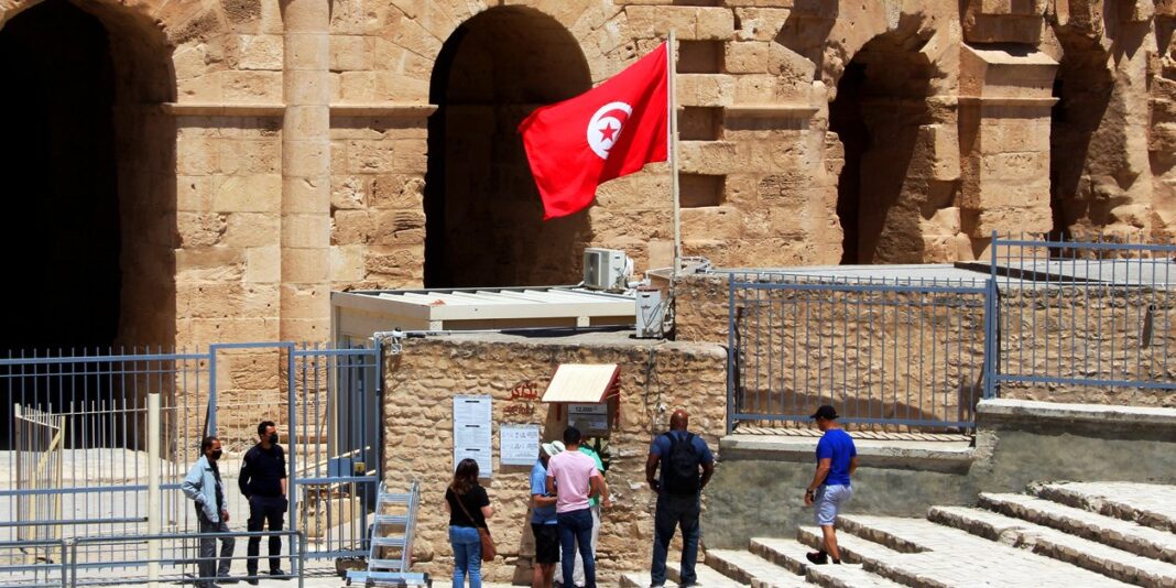 Amphithéâtre romain en Tunisie Amphithéâtre antique en Tunisie avec touristes et drapeau tunisien.