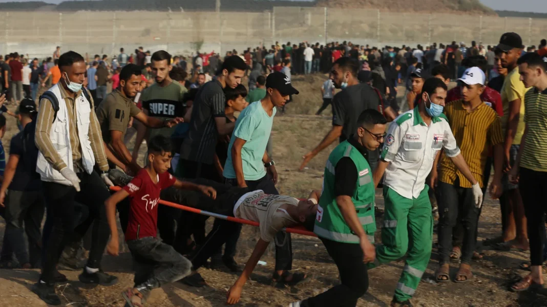 Un Palestinien tombe en martyr sous les balles des… Civils palestiniens lors d'une manifestation, certains portant des masques.