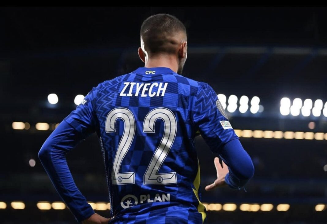 Ziyech en action lors d'un match de football Ziyech portant le maillot du Milan AC, vu de dos, sur le terrain.
