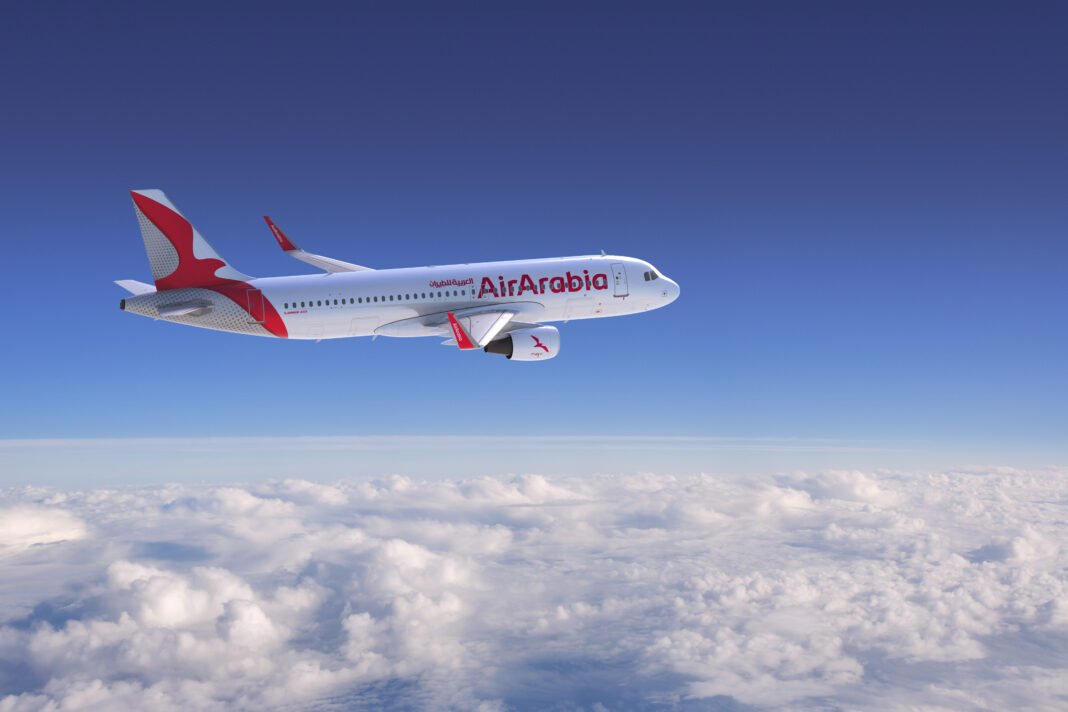 Avion Air Arabia en vol Avion Air Arabia survolant les nuages dans un ciel clair.
