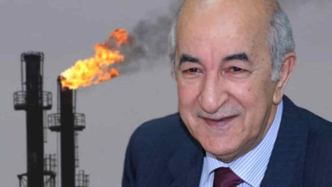 Exportation du Gaz : Tebboune expose l’objectif de l’Algérie pour 2023 Homme d'affaires souriant à côté d'une cheminée de gaz en feu.