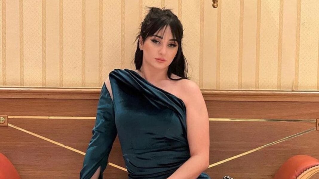 Célia Limam en larmes, vêtue d'une robe bleue élégante.