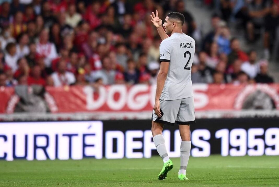 Hakimi en action lors d'un match Hakimi, joueur du PSG, saluant le public sur le terrain.