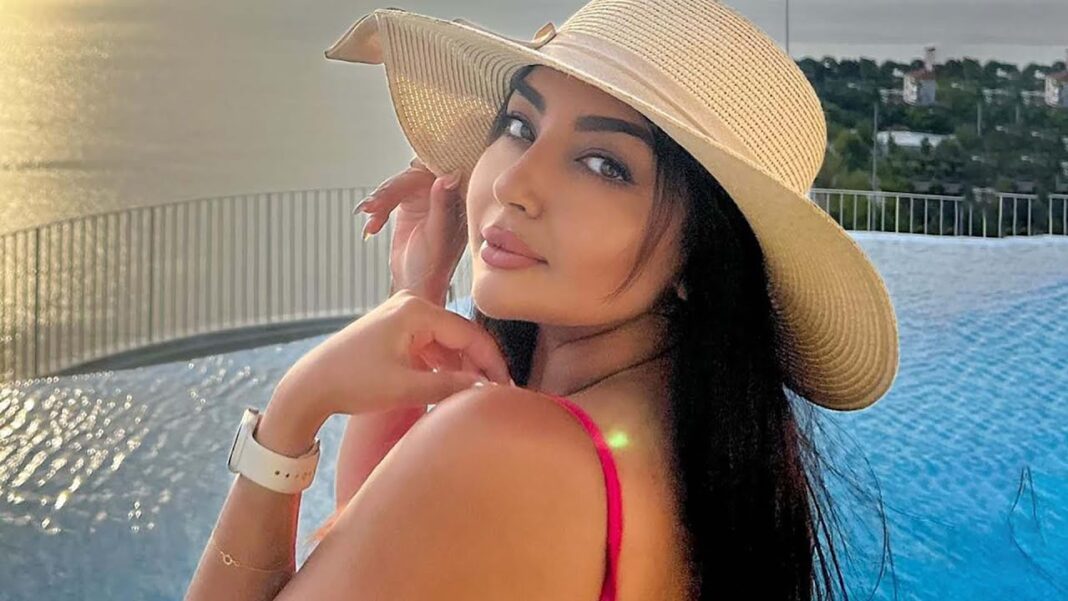 Les confidences de Yasmine Belkacem Femme portant un chapeau de soleil et un maillot rouge près de la piscine.