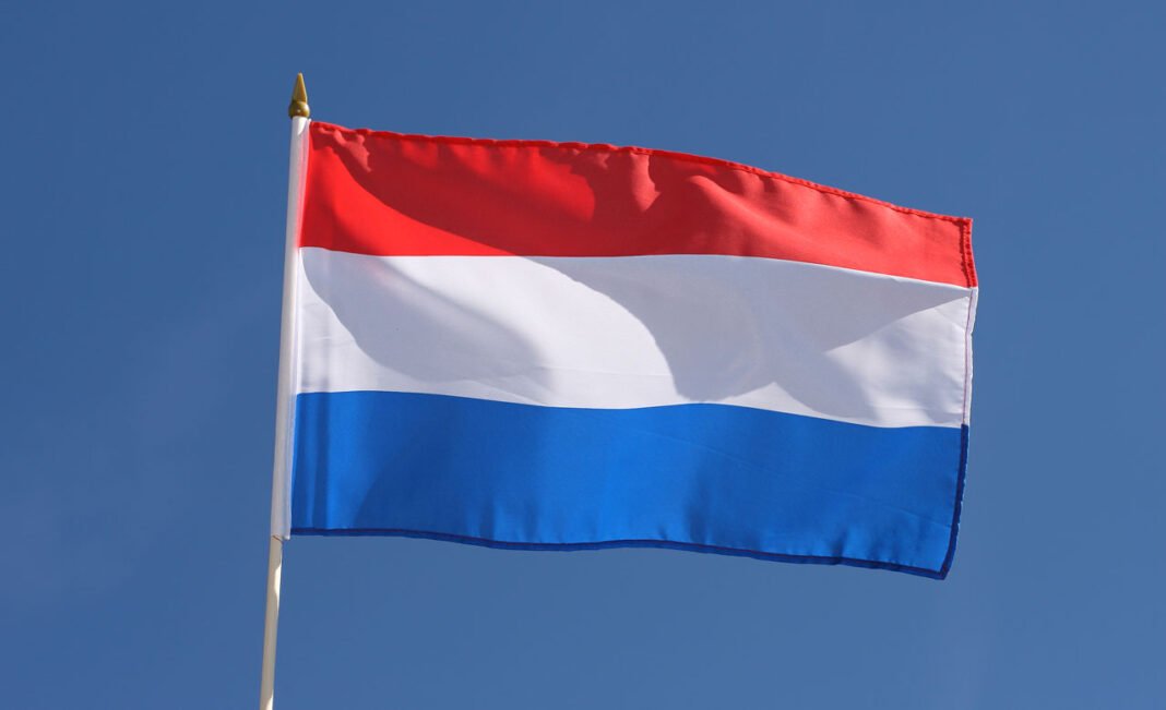 Découvrez la nouvelle et grande opportunité que les Pays-Bas offrent aux Algériens Drapeau des Pays-Bas flottant dans le ciel bleu clair.