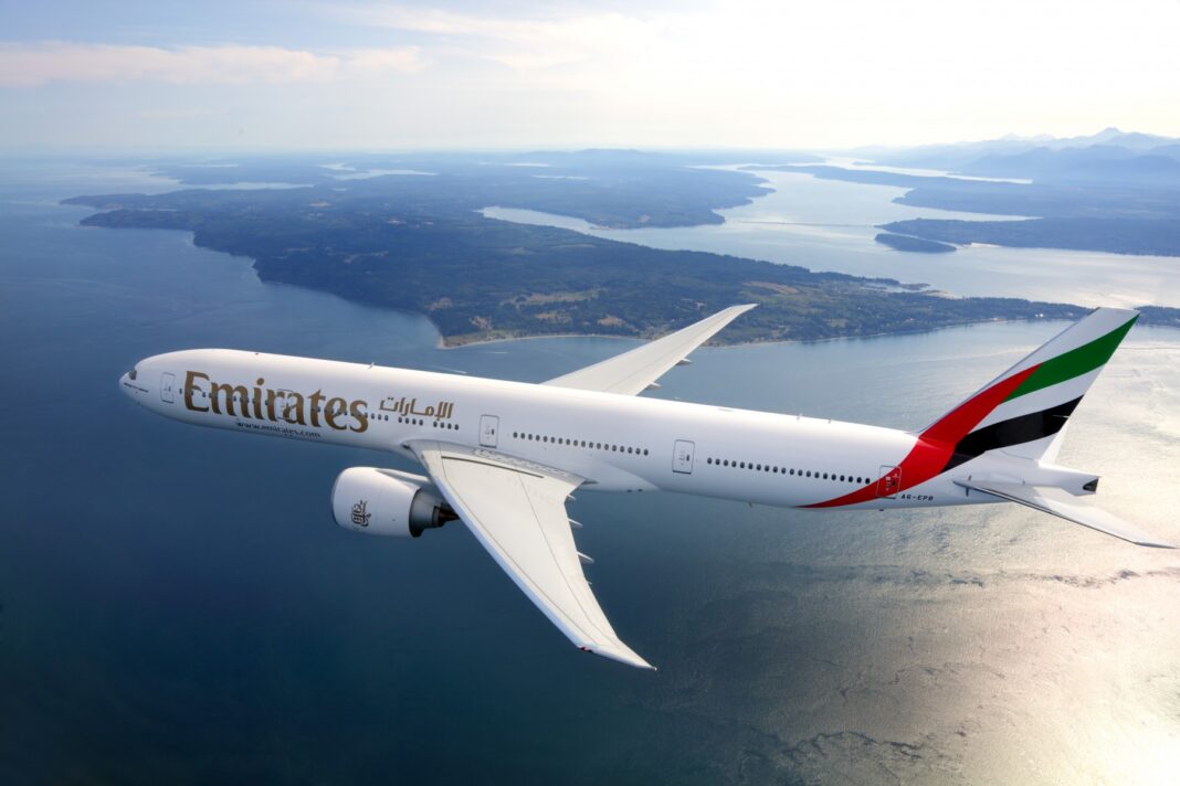 Avion Emirates survolant l'Algérie Avion Emirates en vol au-dessus de l'Algérie avec paysages et lacs.