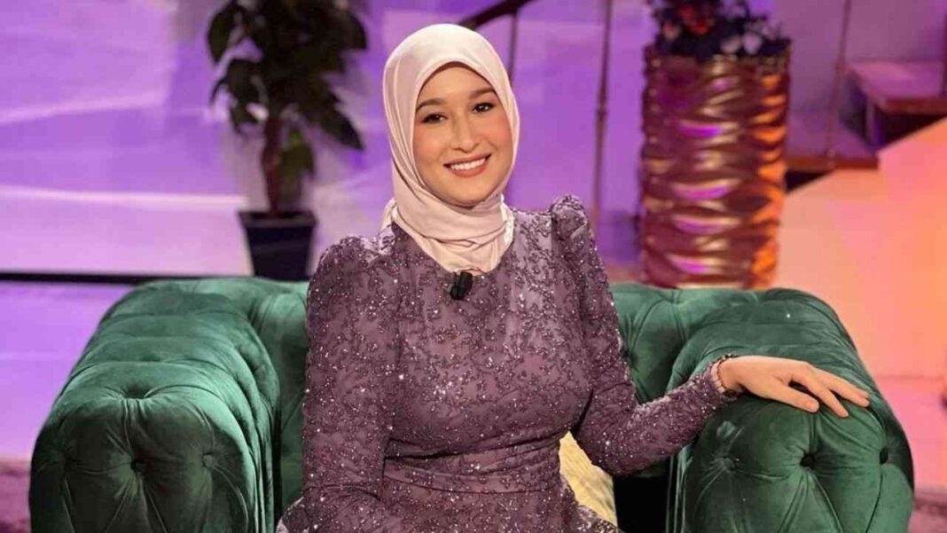 Maya Redjil s’exprime sur un possible mariage Maya Redjil souriante en tenue élégante lors d'une interview.