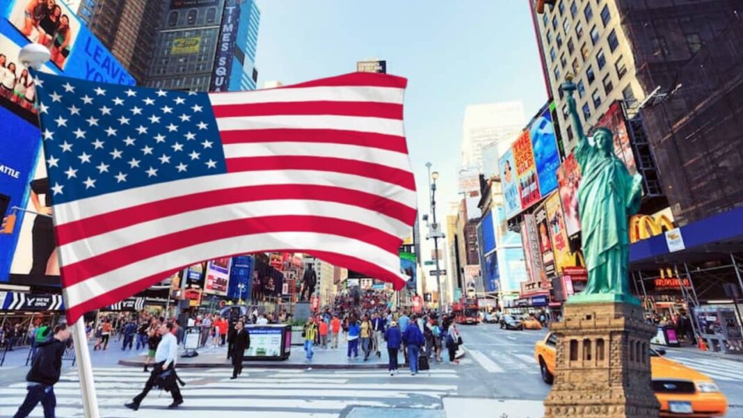 Visa Lottery 2024 : voici la date et les nouvelles conditions d’inscriptions Drapeau américain flottant à Times Square, New York.