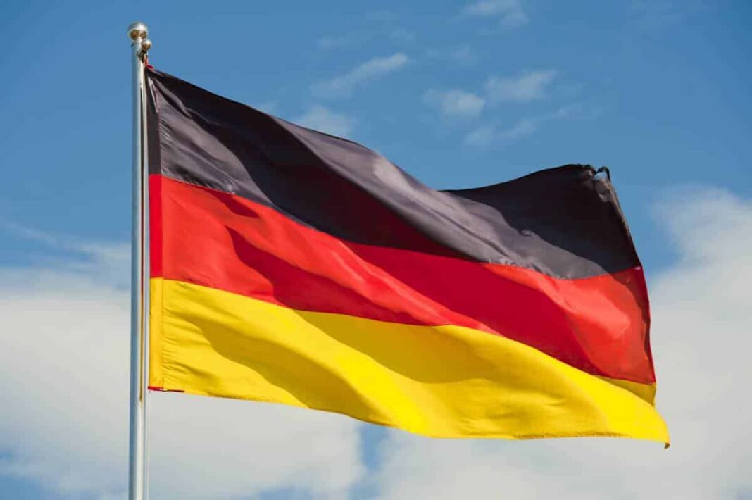 Drapeau national allemand flottant dans le ciel bleu.