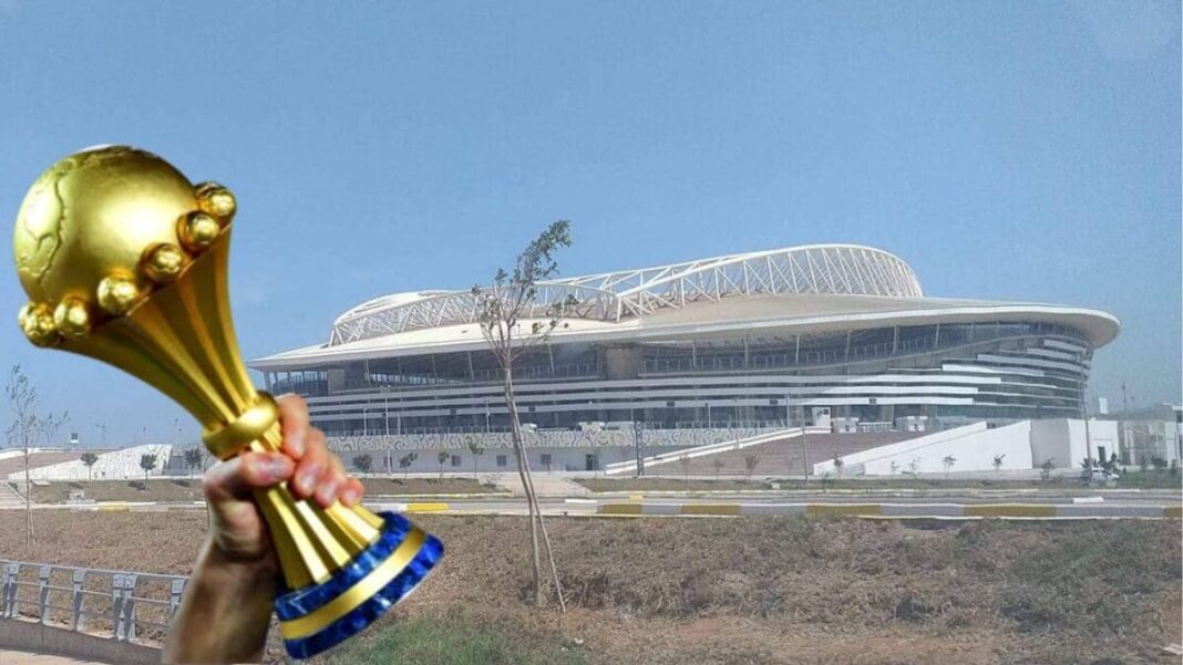 L’Algérie peut-elle décrocher l’organisation de la CAN 2025 ? Stade de Marseille avec un trophée en premier plan.