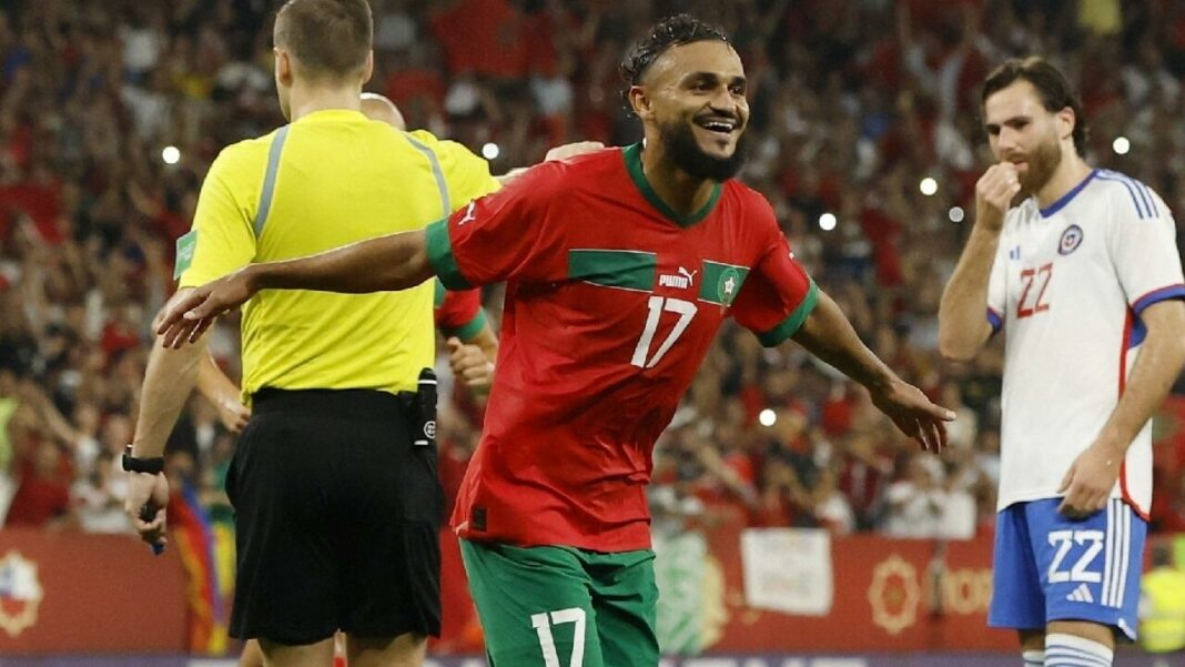 Joueur marocain célébrant la victoire lors d'un match de football.