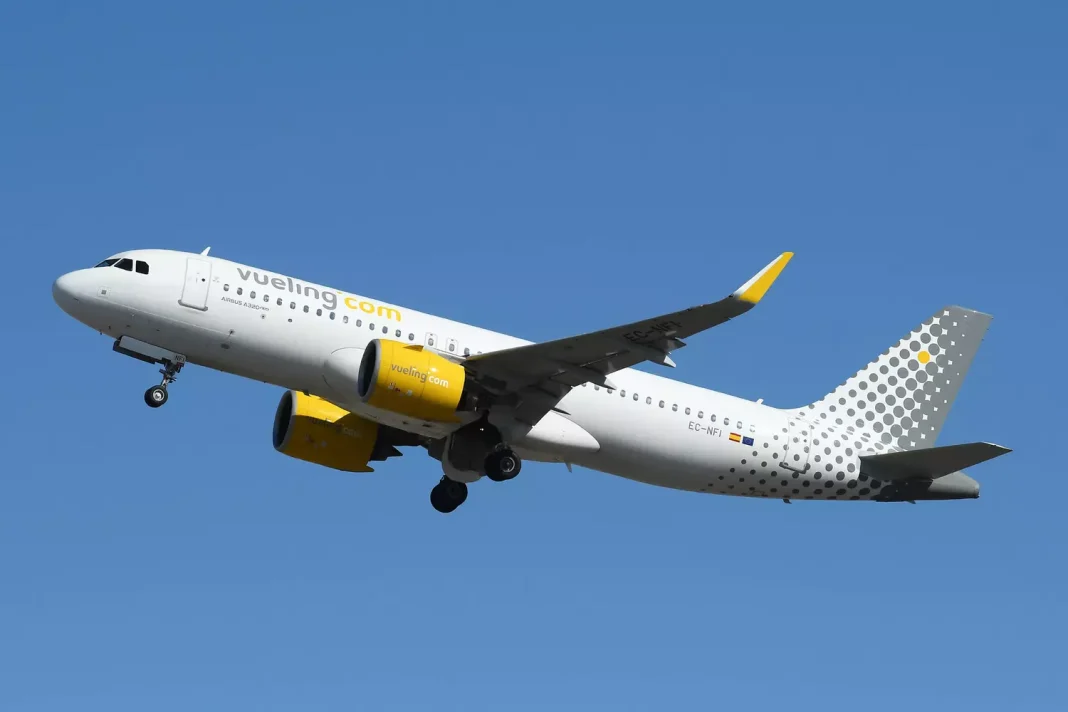 Vols Algérie : Ces tarifs séduisants de Vueling Avion Vueling blanc et jaune en vol dans le ciel bleu.