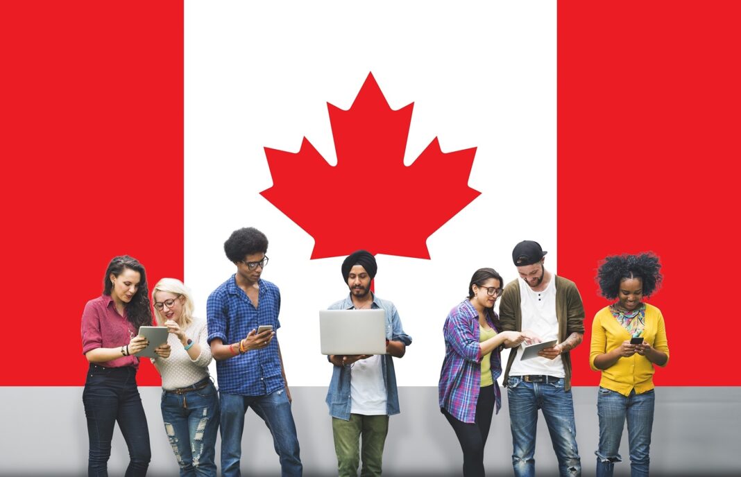 Immigration au Canada : Du neuf pour les étudiants internationaux Groupe d'étudiants devant un drapeau canadien.