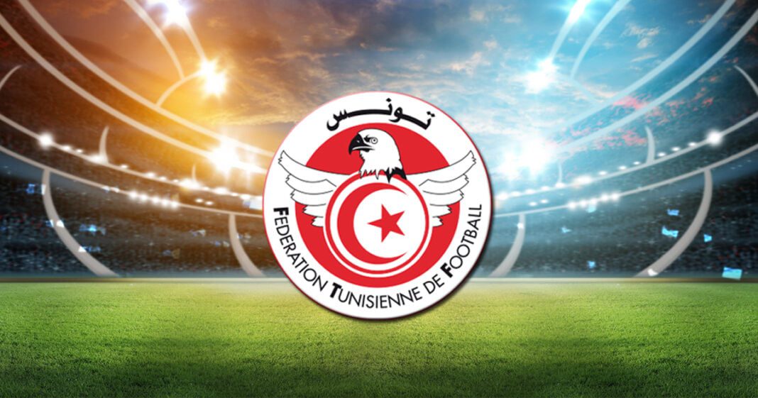 Report surprenant du championnat tunisien : voici la raison Logo de la Fédération Tunisienne de Football sur un stade de football.