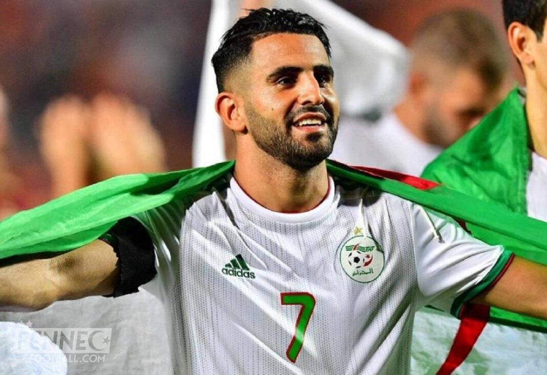 Qatar 2022 : Mahrez sera bel et bien à la coupe du monde Riyad Mahrez en tenue de football avec drapeau algérien.
