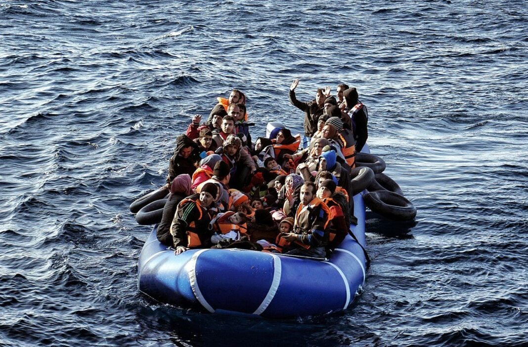 Groupe de migrants sur un bateau gonflable en mer.