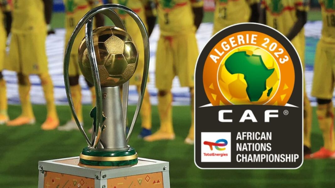 CHAN 2022 en Algérie, la FAF recrute des volontaires : Inscrivez-vous ici Trophée de la CAN 2023 avec équipe de football en arrière-plan.