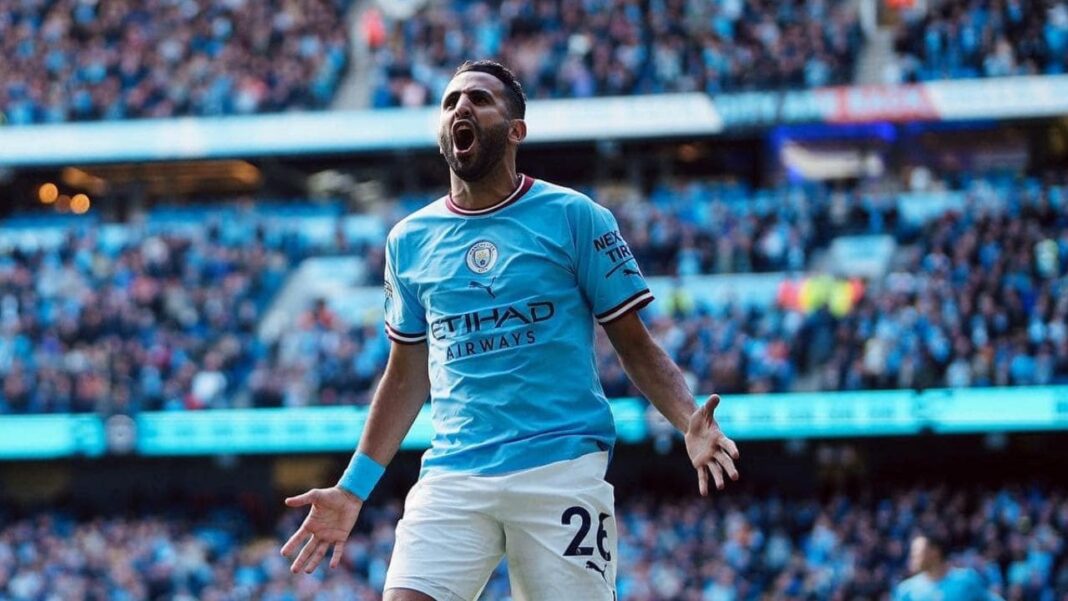 Mahrez en action lors d'un match de football avec foule en arrière-plan.
