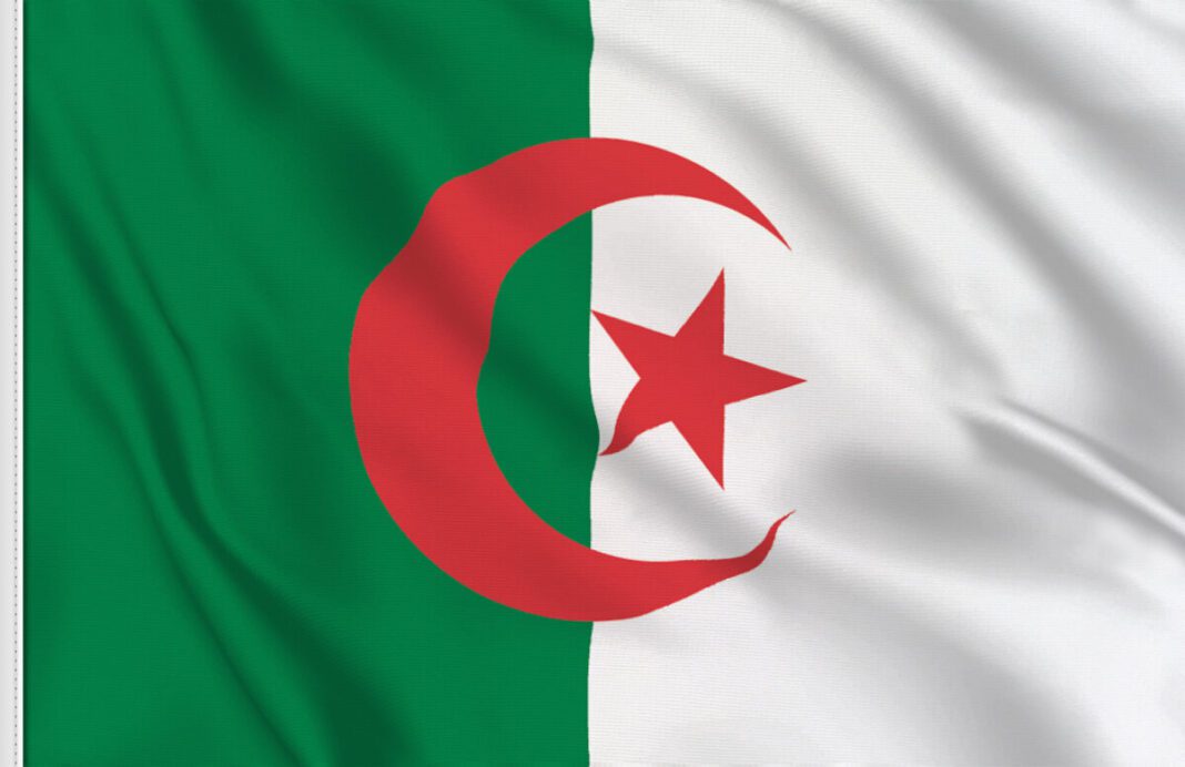 Drapeau algérien flottant avec étoile et croissant rouges.