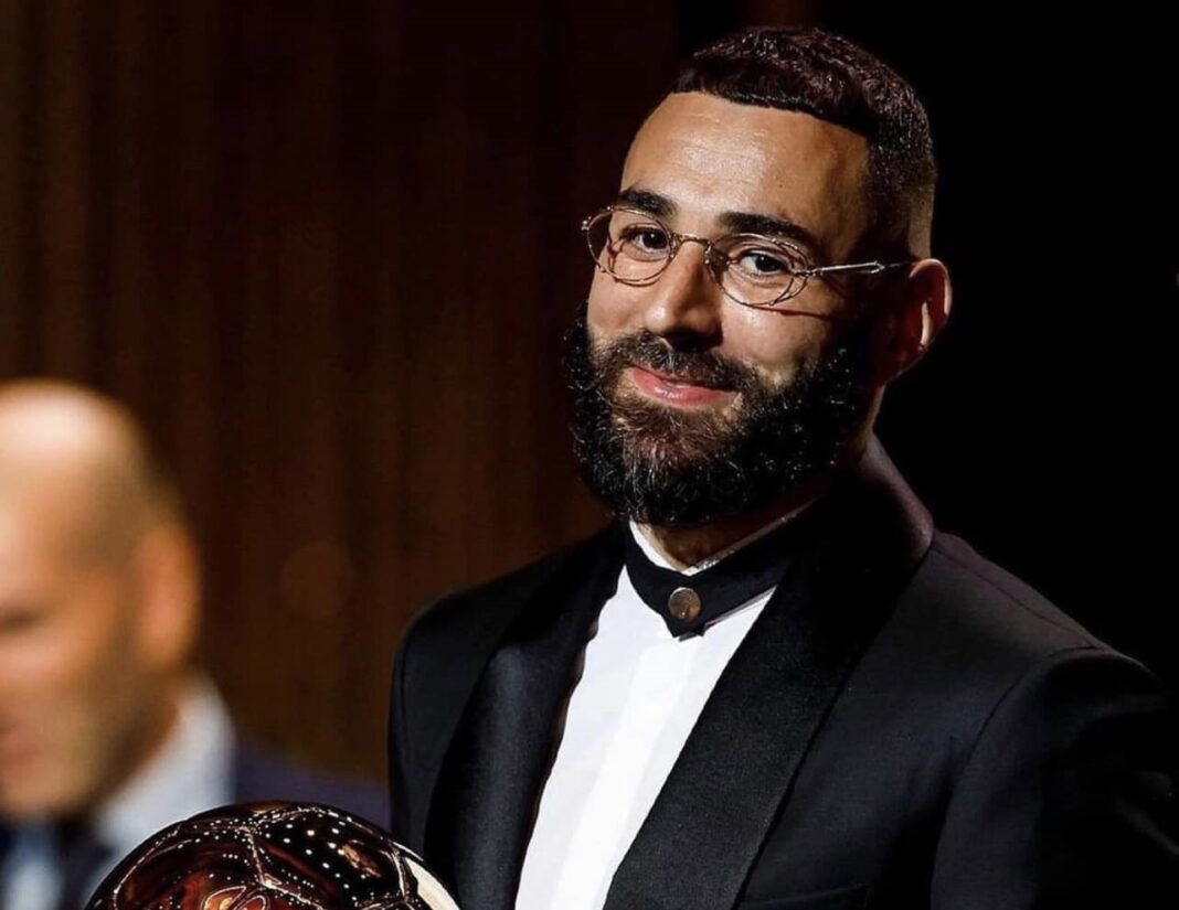 Benzema ballon d’or 2022, une fierté pour son village natal Karim Benzema avec le Ballon d'Or 2022, sourire et élégance.