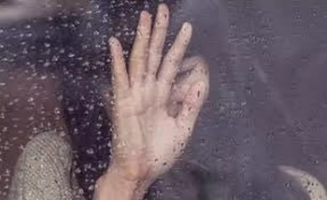France : deux Algériens déposés en prison pour avoir séquestré et violé une femme de 30 ans Femme derrière une vitre, main levée, sous la pluie.