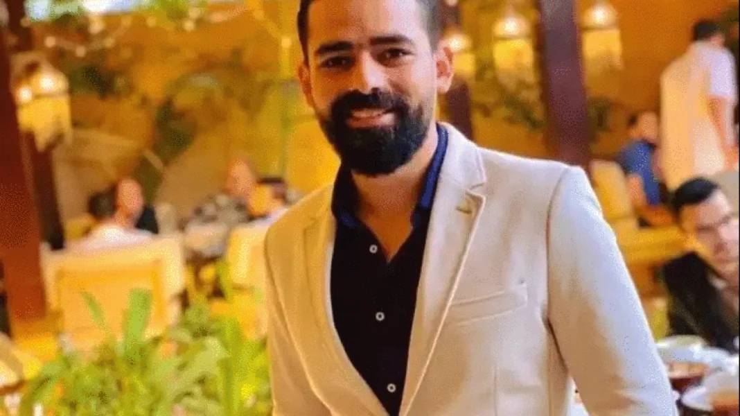 Homme souriant en soirée élégante avec un fond flou de personnes.