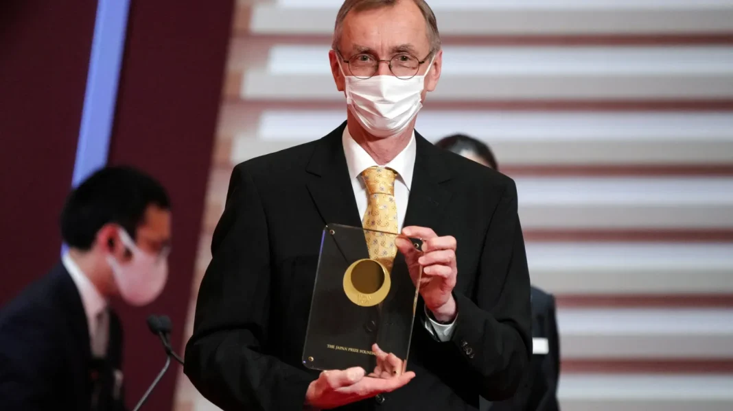 Ce scientifique remporte le prix Nobel de médecine avec cette découverte étonnante Scientifique en costume avec masque, recevant un prix Nobel de médecine.