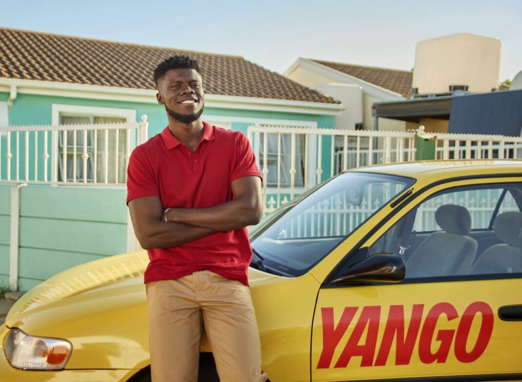 Yango : le géant russe du covoiturage débarque en Algérie Homme souriant à côté d'une voiture Yango en Algérie.