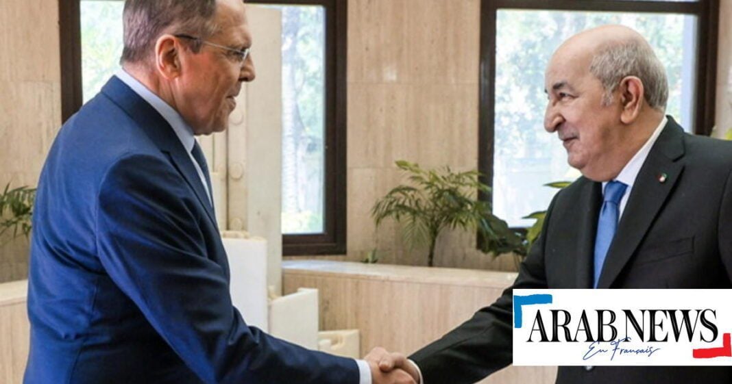 Rencontre diplomatique Algéro-Russe Deux hommes en costume se serrent la main dans un bureau moderne.