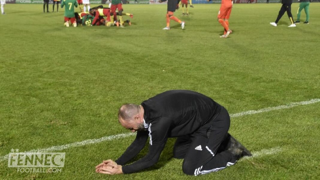 Un entraîneur ou un joueur à genoux sur le terrain de football.
