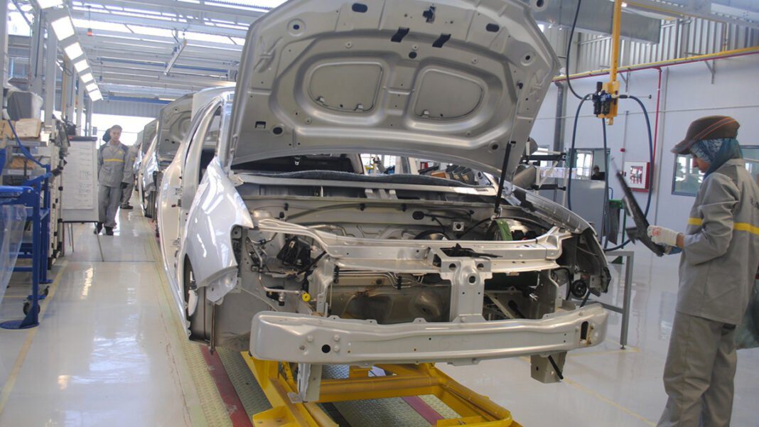 Algérie : le ministère de l’industrie relance le secteur automobile. Usine automobile en Algérie avec ouvriers et véhicules en production.