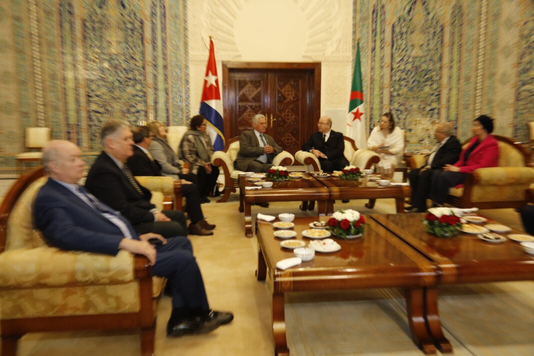 Rencontre diplomatique entre leaders à Alger avec drapeaux Cuba et Algérie.