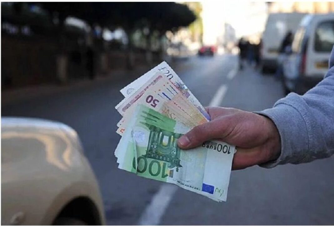 Main tenant des billets de banque en euros et dinars en ville.