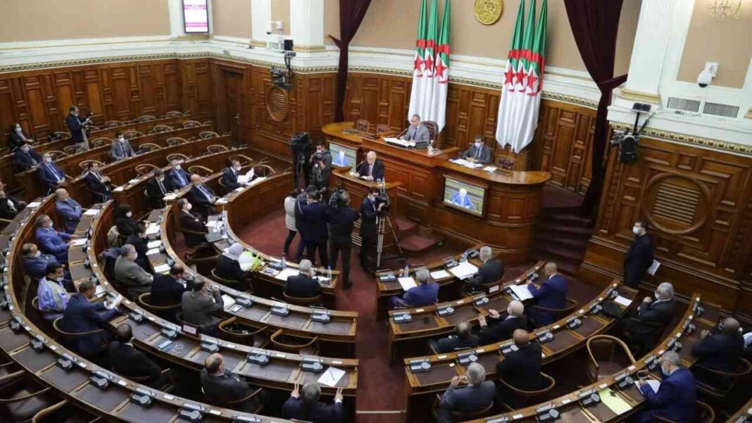 Algérie : voici les conditions d’accès aux congés payés Session parlementaire en Algérie avec députés et drapeaux nationaux.