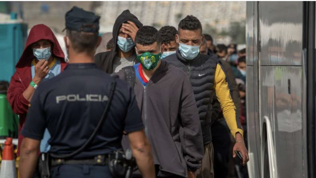 Espagne : Une mineure agressée par un sans-papier d’origine algérienne Groupe de migrants avec masques face à la police en Espagne.